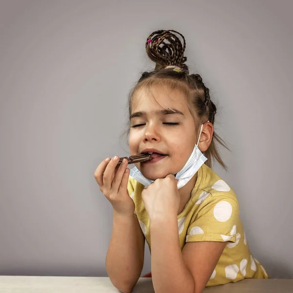 Iskolás Lány Visel Gyógyszer Légzőkészülék Maszk Eszik Csokoládé Szeletek Öröm — Stock Fotó