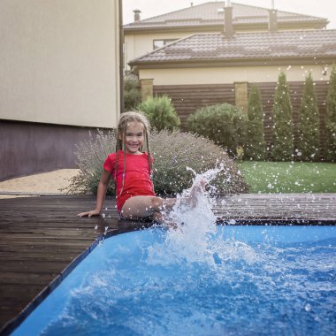 Mutlu şirin kardeş, kız ve erkek kardeş, gün içinde temiz mavi suyla yüzme havuzunun yanında eğlenin ve su sıçratın, mutlu yazlar, dost canlısı aile hafta sonu konsepti, açık hava yaşam tarzı