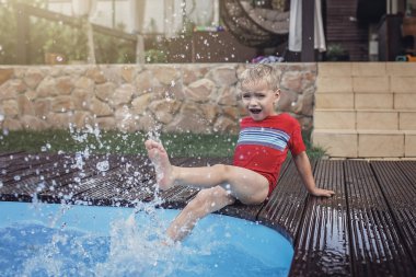 Mutlu şirin kardeş, kız ve erkek kardeş, gün içinde temiz mavi suyla yüzme havuzunun yanında eğlenin ve su sıçratın, mutlu yazlar, dost canlısı aile hafta sonu konsepti, açık hava yaşam tarzı
