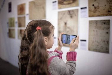 Büyütülmüş gerçeklik mobil uygulaması ile çağdaş bir sanat sergisini araştıran meraklı kız, günlük hayatta gelecek teknolojisi, kapalı bir yaşam tarzı.
