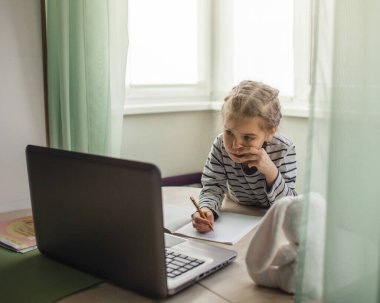 Evdeki çevrimiçi dersi sırasında ev ödevi eğitimi alan oldukça şık bir öğrenci. Karantina sırasındaki sosyal mesafeler, kişisel izolasyon, online eğitim kavramı.