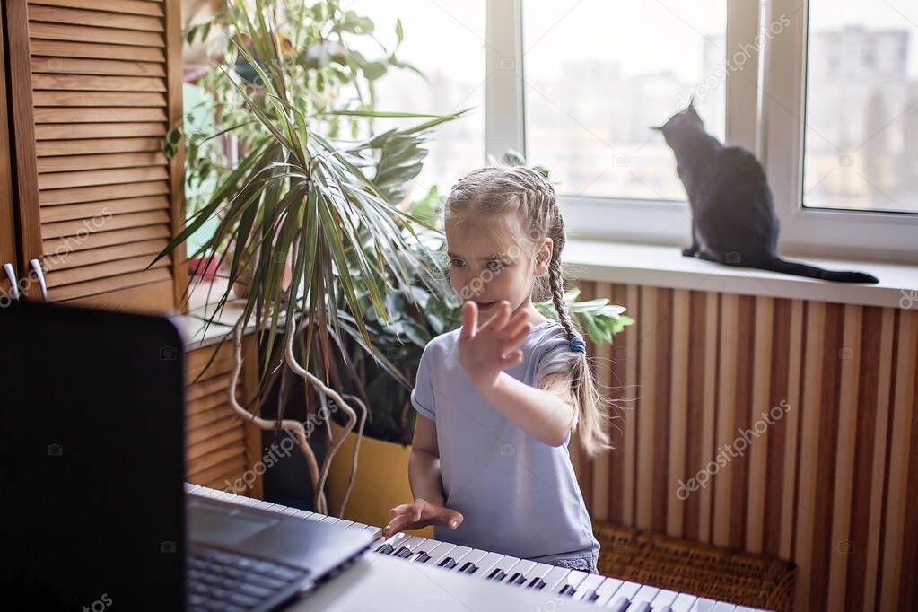 Pretty young musician playing classic digital piano at home during online class at home, social distance during quarantine, self-isolation, online education concept