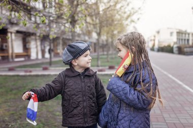 Fransa ve İspanya 'da solunum maskesi takan mutlu küçük çocuklar ülkedeki karantina sona erdiği için bayrak rengi, mutluluk ve umut, virüsün yayılmasını durdurmak, açık hava yaşam tarzı