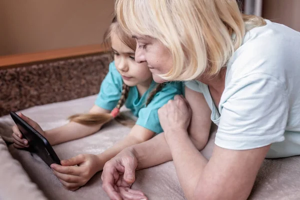 幸せな孫は ポータブルタブレットを使用し セルフィーを作るために彼女の祖母を教えて オンライン生活 コロナウイルスパンデミック後の新しい正常な 幸せな銀サーファーデジタルネイティブ世代 — ストック写真