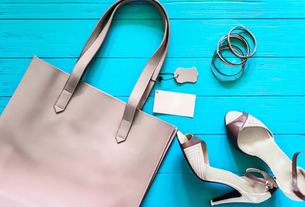 Mujer plana lay fashion stuff: bolso gris con etiqueta vacía y espacio libre para el texto, zapatos de tacón alto, conjunto de pulseras de plata . Fotos De Stock