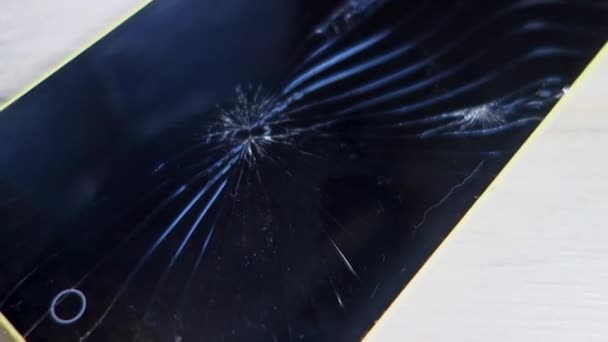 Broken screen of a smartphone, closeup on a wooden table. Outdoor camera. — 비디오