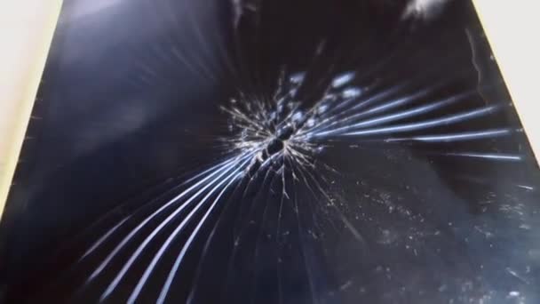 Écran cassé d'un smartphone, gros plan sur une table en bois. Caméra extérieure .