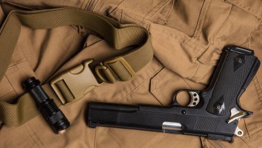 Meşale ve kahverengi kumaş üzerinde silah.