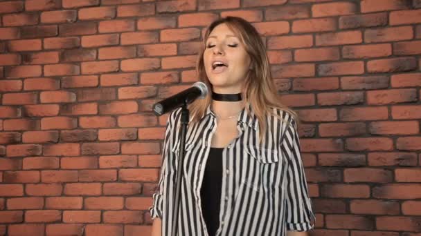 Девушка-певица поет в студии — стоковое видео