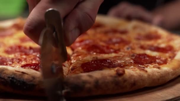Kuchař krájí pizzu nožem na pizzu. Šťavnaté, čerstvé feferonky s měkkým sýrem a opečenou kůrkou