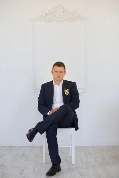 Muž v obleku, sedí na židli — Stock fotografie