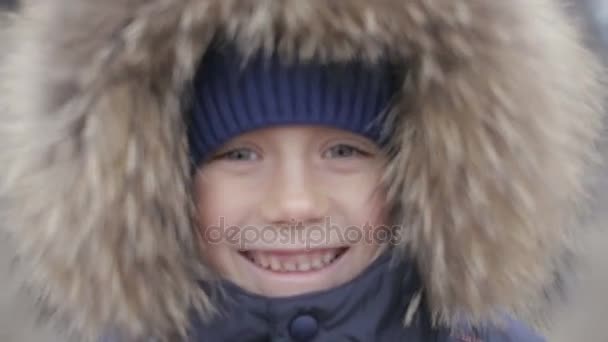 Πορτρέτο του ένα αγόρι στο χειμερινό μπουφάν με κουκούλα στο κεφάλι του — Αρχείο Βίντεο