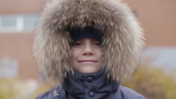 Portréja egy fiú téli kabát, kapucnival a fején — Stock videók