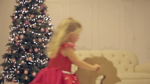 Malá dívka na koni hračky v New Years Eve — Stock video