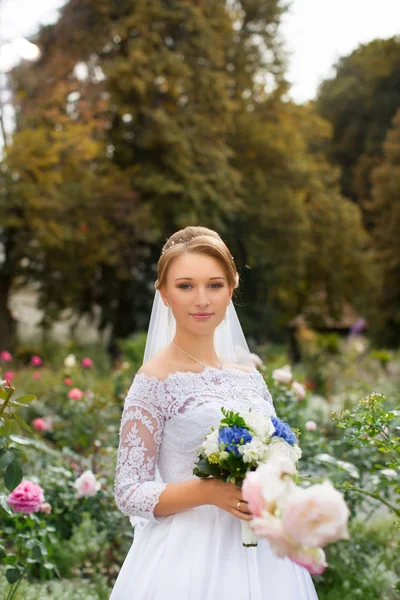 La ragazza in un abito da sposa con mazzo di fiori — Foto Stock