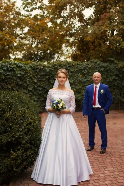 Fotografia di nozze sposi su una passeggiata — Foto Stock