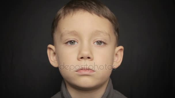 Retrato de un niño de cerca sobre un fondo negro. Vídeo completo hd — Vídeo de stock
