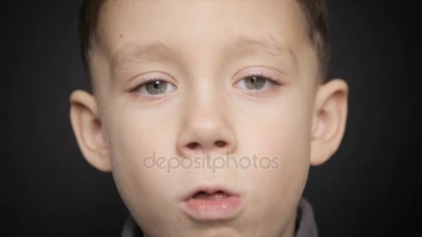 Egy hideg fiú közelkép egy fekete háttér — Stock videók