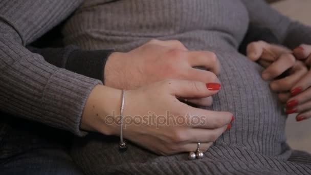 Mannelijke en vrouwelijke handen strelen zwangere buik — Stockvideo