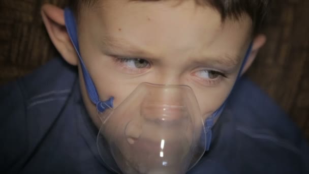 The boy is breathing through the inhaler — Stock Video