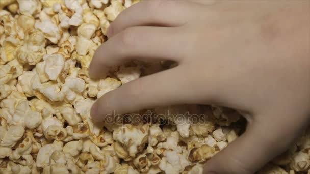 Ребенок берет попкорн крупным планом. — стоковое видео