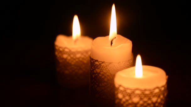 Три горящие свечи в темноте — стоковое видео