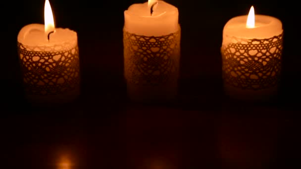 Tres velas encendidas en la oscuridad — Vídeos de Stock