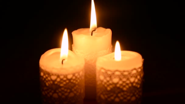 Три горящие свечи в темноте — стоковое видео