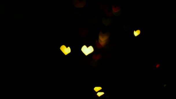 Освітлення прикраси гірлянди блимає на фоні боке у формі серця . — стокове відео
