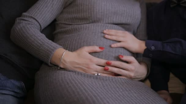 Mužské a ženské ruce pohladí těhotné bříško — Stock video