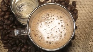 Cam fincan kapuçino ve bir bardak su Sivas'tan üzerinde etrafında kahve taneleri