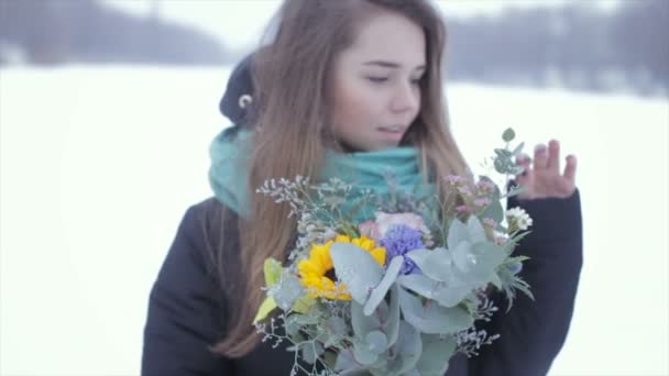 Tjej med en bukett blommor på en frusen sjö. Slow motion — Stockvideo