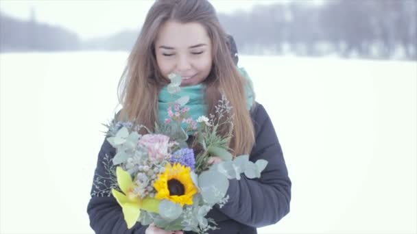 Chica con un ramo de flores en un lago congelado. — Vídeos de Stock