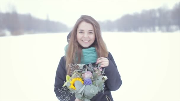 Bir buket çiçek donmuş bir gölün üzerinde olan kız. Ağır çekim — Stok video