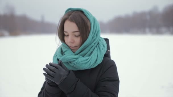 Ella calienta sus manos en invierno de pie en la nieve. Vídeo completo hd — Vídeos de Stock