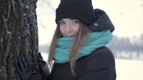 Chica feliz con ropa de abrigo de pie cerca del árbol. Vídeo completo hd — Vídeos de Stock