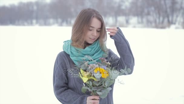 凍った湖の上に花の花束を持つ灰色のセーターの女の子との愛します。 . — ストック動画