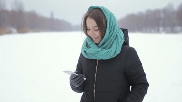 쾌활 한 여자는 겨울에 거리에서 전화, 말한다. 슬로우 모션 — 비디오