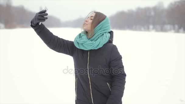 Dziewczyna w zielony szalik i czarna kurtka sprawia, że selfie — Wideo stockowe