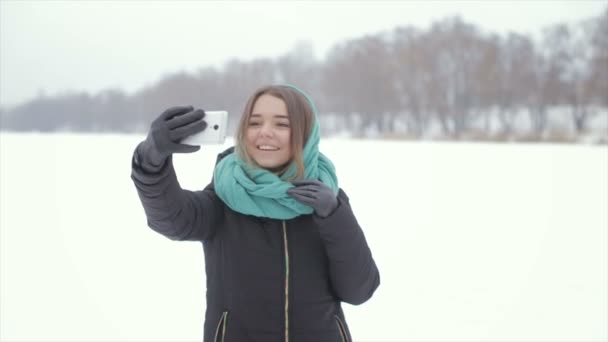 Дівчина в зеленому шарфі і чорна куртка робить селфі — стокове відео