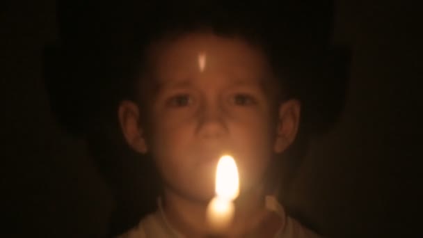 Bir çocuk yanan muma elinde tutar. — Stok video
