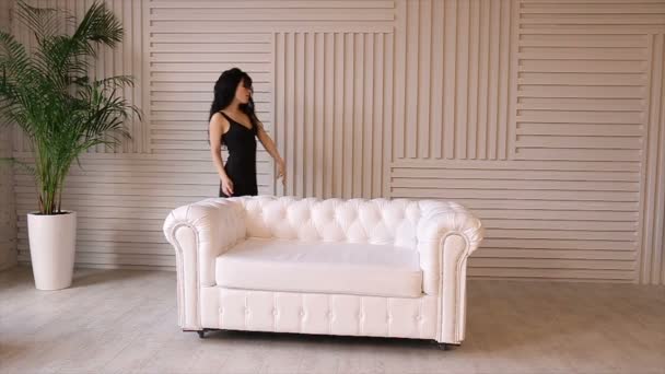 Menina sexy posando em couro branco sofa.Full hd vídeo — Vídeo de Stock