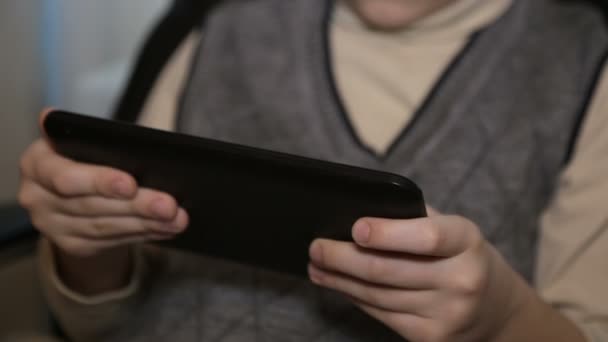 Bir deri sandalyede çocuk elinde bir tablet ile — Stok video