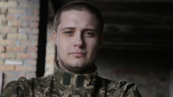 Un homme en uniforme militaire sur un bâtiment abandonné — Video