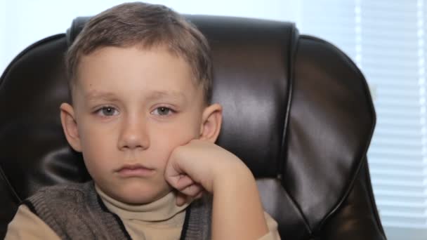 Ernstige jongen in kantoor op fauteuil, close-up — Stockvideo