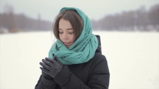 彼女は雪の中で冬に立っているを彼の手を暖めます。フル hd ビデオ — ストック動画
