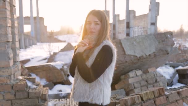 Meisje met een schapenvacht vacht op een achtergrond van een verlaten building.slow beweging — Stockvideo