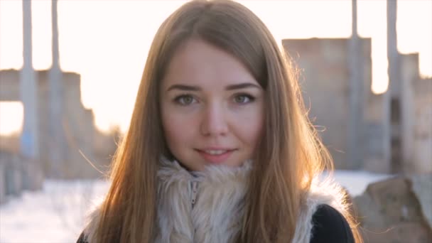 Κορίτσι σε ένα sheepskin παλτό με φόντο ένα εγκαταλελειμμένο building.slow κίνηση — Αρχείο Βίντεο