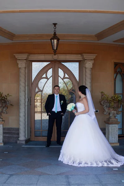 Jonggehuwden poseren tegen de retro deur — Stockfoto