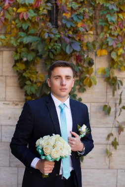 Bir tuğla duvar arka plan şık elbiseli damat